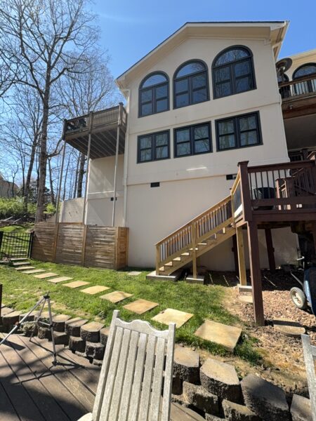 The work performed consists of soft washing and rinsing the primary structure's exterior surfaces, three rear decks, a treehouse with its decks and bridges, and surface cleaning the concrete flatwork, all backed by a one-year warranty against mold and mildew regrowth.