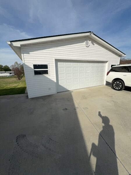 Professional soft wash exterior cleaning will be performed on the main house, porches, and three garage buildings, targeting all vertical surfaces and roofline components to remove organic growth and debris with a one-year warranty.
