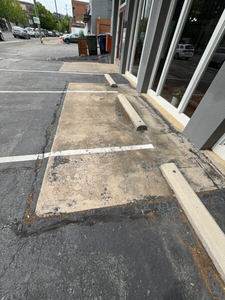 This project involved an after-hours exterior cleanup of a commercial parking area in Chattanooga, which included removing leaf debris and weeds, pressure washing concrete surfaces with detergents to eliminate mold and grime, and applying specialized treatments to remove black spray paint from concrete pads and steps.
