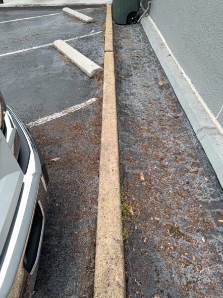 This project involved an after-hours exterior cleanup of a commercial parking area in Chattanooga, which included removing leaf debris and weeds, pressure washing concrete surfaces with detergents to eliminate mold and grime, and applying specialized treatments to remove black spray paint from concrete pads and steps.