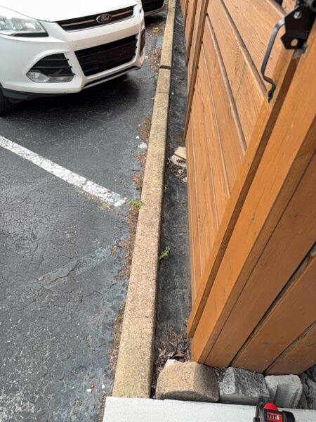 This project involved an after-hours exterior cleanup of a commercial parking area in Chattanooga, which included removing leaf debris and weeds, pressure washing concrete surfaces with detergents to eliminate mold and grime, and applying specialized treatments to remove black spray paint from concrete pads and steps.