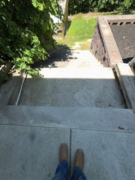 This comprehensive exterior cleaning project involved a full soft wash of the home's surfaces, a dedicated pressure wash of concrete hardscapes and retaining walls, and a gentle cleaning of the wood deck and mailbox to remove organic growth and restore the property's appearance.