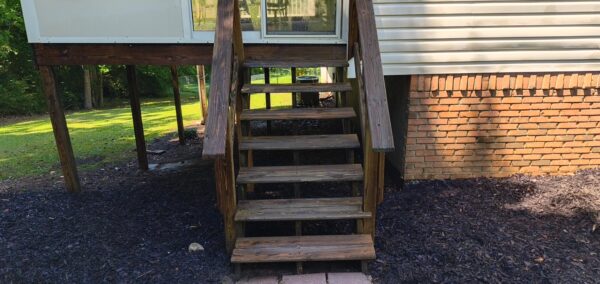 This project involved a comprehensive soft wash of the home's exterior and screened porch, complemented by surface cleaning of the concrete driveway, walkways, and a retaining wall to remove organic growth and debris.