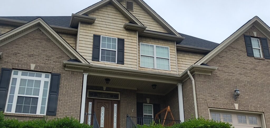 The project involved a comprehensive soft wash of a two-story home's multi-material exterior and wood deck in Apison to remove organic growth and debris, backed by a one-year mold and mildew warranty.