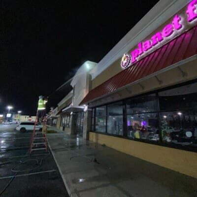 Using a ladder to clean shopping center in chattanooga tn by qualitypro power washing